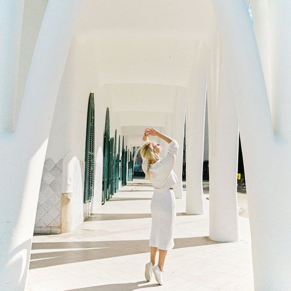Person stretching in a bright, sunlit space.